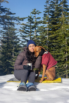 Sitting on the snow, girl and dog