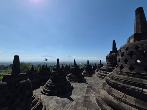 Stupas de Borobudur en contre-jour face aux volcans de Java au lever du jour