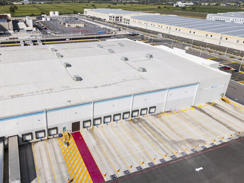 Aerial view of a large modern logistic center with numerous loading docks and numbered bays in an industrial park in Santiago de Queretaro, Queretaro, Mexico.