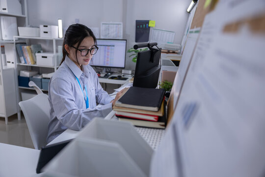 Office worker woman computer desk paper document eyeglass workspace business office worker woman reviewing document computer desk modern workspace with eyeglass paper folder monitor shelf calm