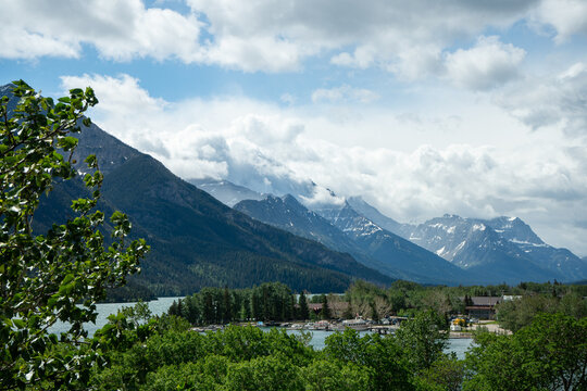 Panoramic Mountain Lake Vista with Clouds and Lush Forest Landscape Under a Bright Sky