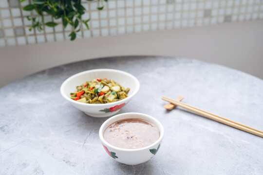 A bowl of cuttlefish and Job's-tears porridge served with stir-fried sour long beans.