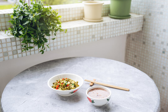 A bowl of cuttlefish and Job's-tears porridge served with stir-fried sour long beans.