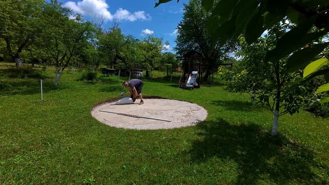 Preparing the ground for a pool in a backyard during summer with leveling and sand