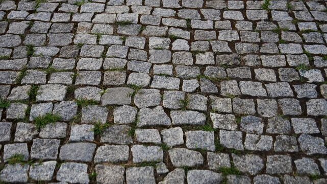 Close up shot of an ancient cobblestone road paved with neatly arranged cut stones.