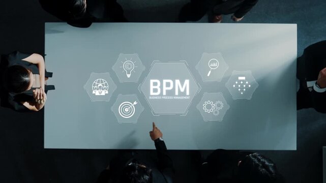 This image captures professionals discussing business process management concepts at a conference table, highlighting teamwork and strategic planning in a corporate setting. Raster