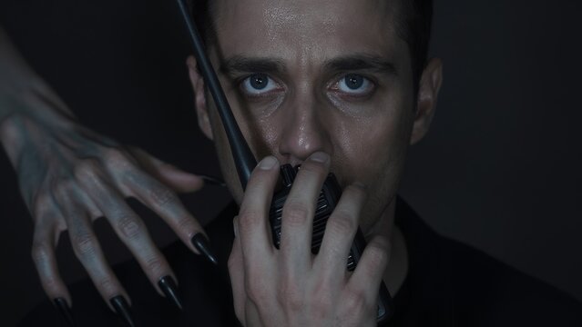 Intense Portrait of Man Holding Microphone with Mysterious Hand