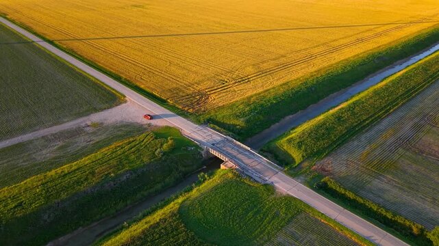 Aerial view of a single car at cross roads in the middle of fields in a rural landscape