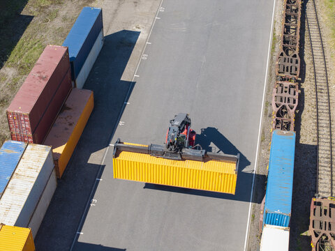 Aerial view of a reach stacker moving a yellow shipping container at the Polzug Intermodal Polska Terminal in Dabrowa Gornicza, Wojewodztwo Slaskie, Poland.