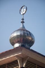 Reflective chrome onion dome with religious symbol against clear blue sky for editorial use only © ketut