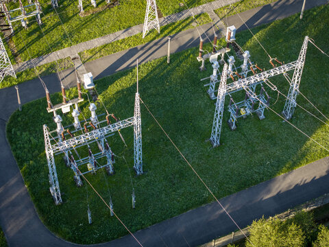 Aerial view of GPZ Trzebinia electrical substation featuring high voltage equipment, metal structures, and power lines set within a green grassy area in Trzebinia, Lesser Poland Voivode, Poland.