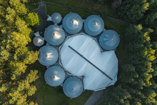 Aerial view of Alvernia Planet with its distinctive dome-shaped structures surrounded by lush green forest in Nieporaz, Malopolskie, Poland.