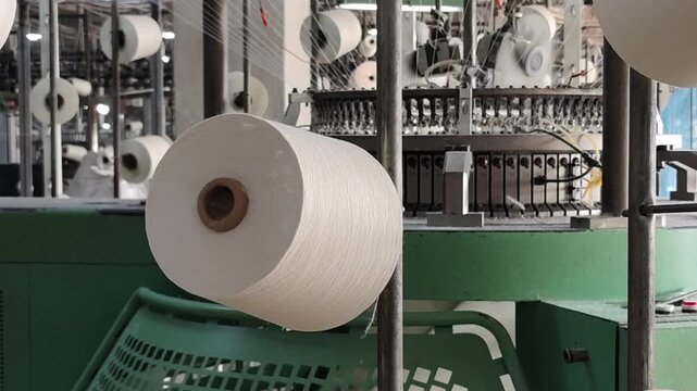 Close-up of textile machinery operating at a yarn factory.