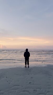 Person Standing on Beach at Sunset
