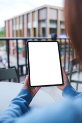 Vertical mockup image of a woman holding digital tablet with blank white desktop screen in cafe © Farknot Architect