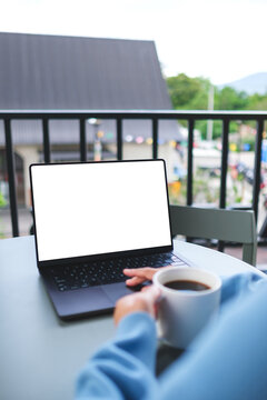 Vertical mockup image of a woman working on laptop computer with blank white desktop screen while drinking coffee in cafe
