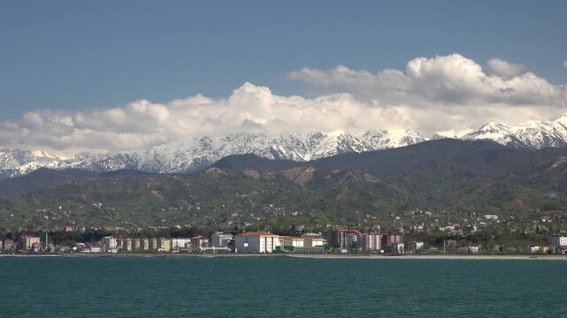 Rize Turkey Black Sea coastal city stands below snowy Pontic mountains and cloudy sky.