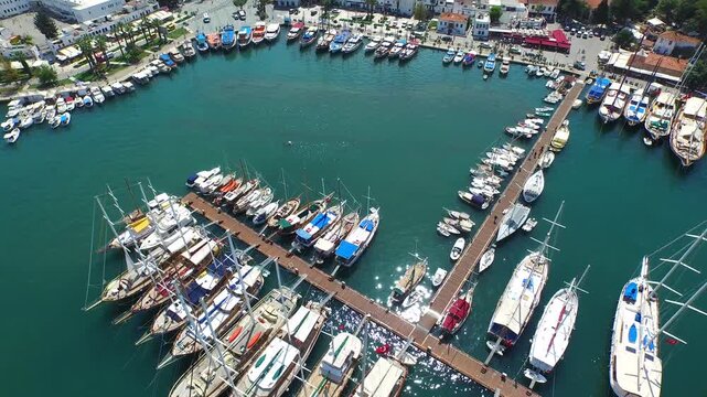 Aerial yachts at Bodrum marina, turquoise water, busy summer resort harbor scene.