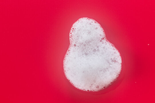 Rounded soap foam patch on red with copy space