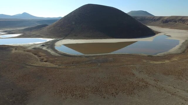 Aerial view of tuff ring cone and volcanic crater lake maar in a barren caldera of Konya Turkiye.