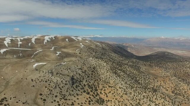 Aerial drone Kizlarsivrisi Mountain with spring dome peak with patchy snow above Elmali region.
