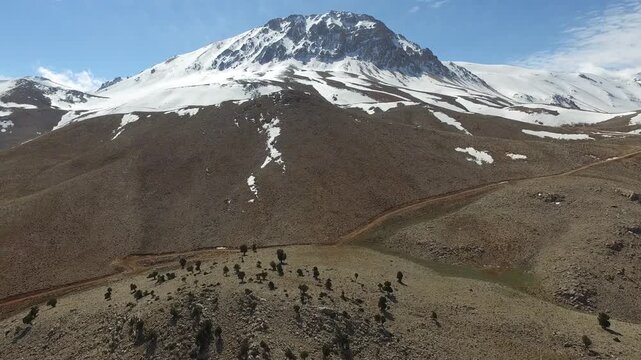 Aerial drone Kizlarsivrisi Mountain with spring dome peak with patchy snow above Elmali region.