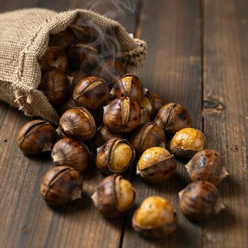 Roasted chestnuts tumbling from a burlap sack in close up