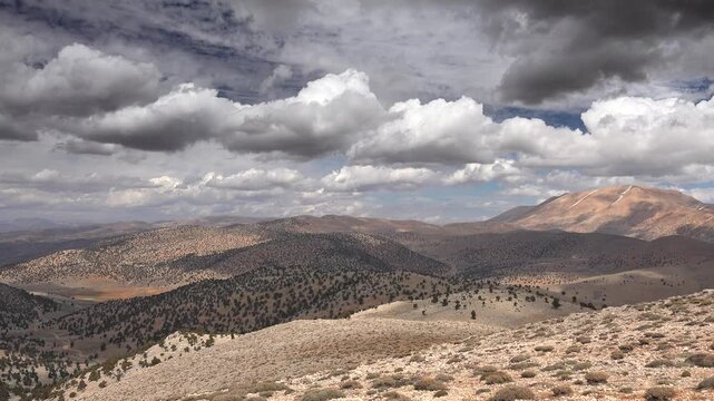 Panoramic semiarid mountain landscape with sparse trees under dramatic clouds Pakistan.