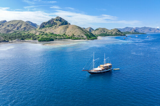 Aerial view of the natural scenery of Komodo National Park in Indonesia as a boat sails in the Indian Ocean.