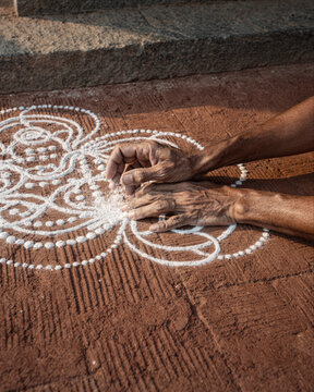 Hands Drawing Traditional Rangoli with White Rice Flour