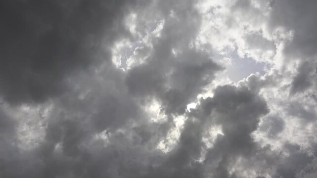 Storm clouds above green hills rain curtains shifting weather light evening weather detail.