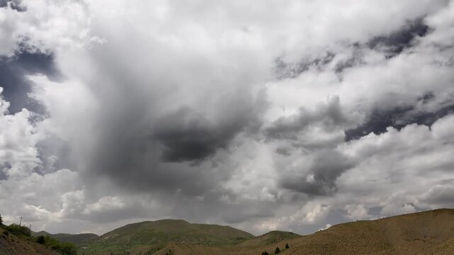 Clouds disperse above the Andes in Chile, revealing lower hills and brightening mountain air.