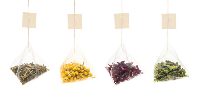 Four pyramid tea bags with herbal blends and dried flowers isolated on white background