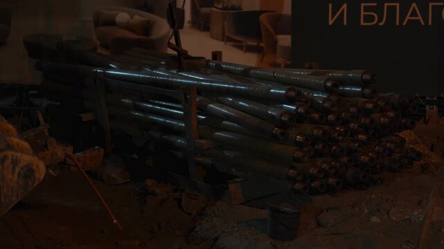 A stack of long heavy drill pipes at construction site.