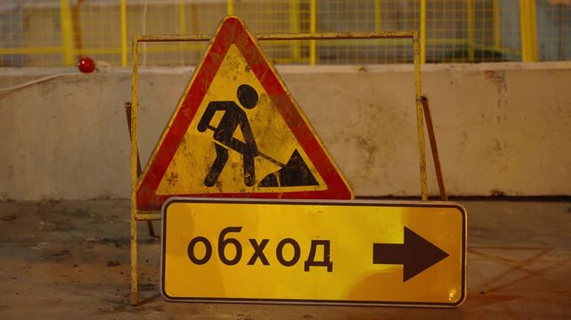 Temporary road signs for construction work indicating a detour ahead.