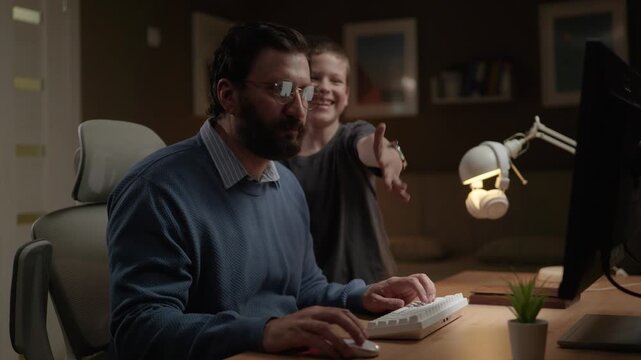 Father freelancer at work. Man with glasses working on computer while child constantly distracts him