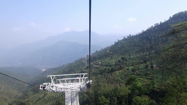 Scenic view of the Manakamana Cable Car traveling through the lush green mountains of Gorkha, Nepal. The ropeway connects visitors with the famous Manakamana Temple, a major Hindu pilgrimage
