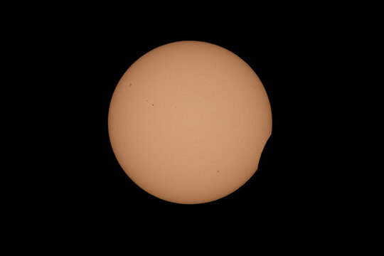Aerial view of a partial solar eclipse with the moon obscuring part of the sun against a dark sky in Mulhouse, Grand Est, France.