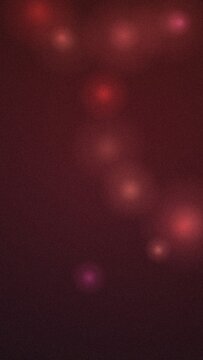 Abstract background, featuring soft red, light orbs and, glowing particles on, a dark maroon surface