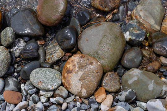 sand and gravel shoal along the shoreline of a shallow river on a sunny day, close-up and soft focus