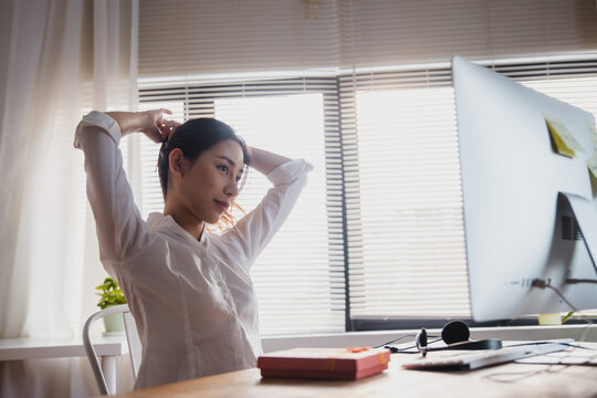 Man with headphones holding gift box during online video call at home office