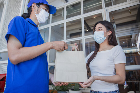 Delivery worker handing food package to customer at home doorway