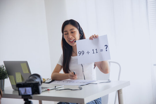 Young woman recording online video lesson with laptop and camera at home studio