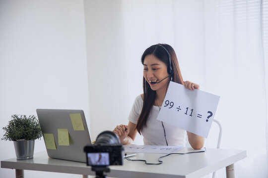 Young woman recording online video lesson with laptop and camera at home studio
