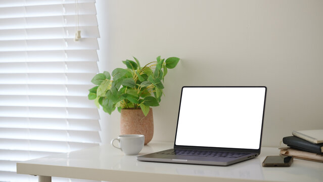 Blank laptop screen displayed on a minimal home office desk for a digital mockup.
