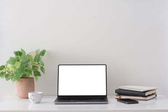 Blank laptop screen displayed on a minimal home office desk for a digital mockup.