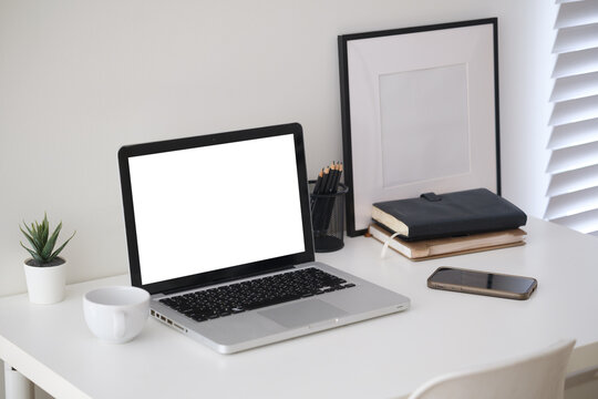 Blank laptop screen displayed on a minimal home office desk for a digital mockup.
