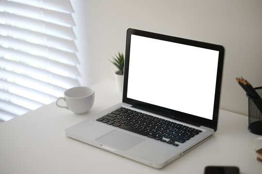 Blank laptop screen displayed on a minimal home office desk for a digital mockup.
