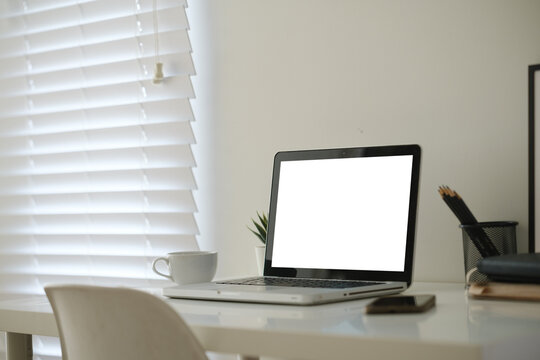 Blank laptop screen displayed on a minimal home office desk for a digital mockup.