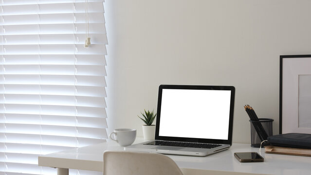 Blank laptop screen displayed on a minimal home office desk for a digital mockup.